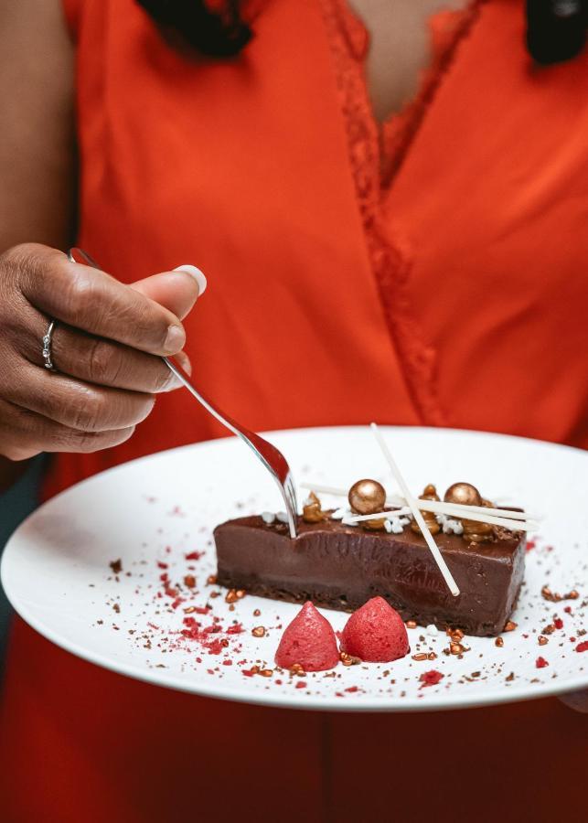Boutique Hotel Texel De Cocksdorp  Exterior photo A server cutting a piece of chocolate cake